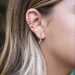 Macro shot of gold snake ear cuff and stud with detailed scale texture on the ear