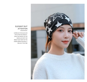 Close-up of black knitted slouchy beanie with white star print on a female model