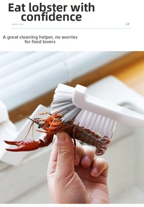 Close-up of long-handle brush cleaning a crayfish with dense white and gray bristles
