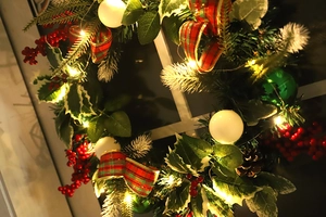 Detailed view of a 50cm Christmas wreath with LED lights, pine cones, and red berries