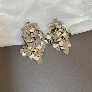 Close-up of cascading silver metal sequins on long fringe earrings with polished finish