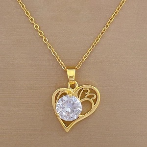 Macro view of gold heart pendant with zircon stone and filigree on O-chain necklace