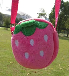 Detail of pink strawberry plush crossbody bag with green leaf top and adjustable strap