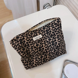 Detail view of leopard print canvas makeup bag with a metal zipper and simple wish label