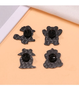 Detail view of four black metal pins with secure rubber backings on an orange background