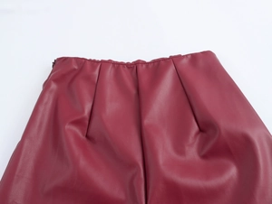 Détail de la taille du pantalon en similicuir bordeaux avec plis et zip latéral