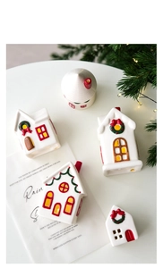 Top view of assorted colorful ceramic Christmas house ornaments on a white surface