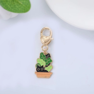 Close-up of heart-shaped lobster clasp and enamel black cat in a potted plant pendant
