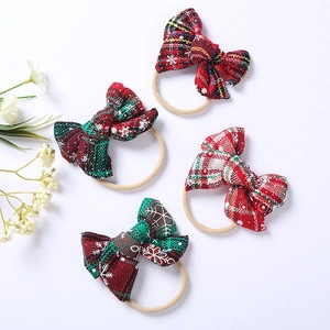 Detail of 4-pack Christmas bow hairbands with red green plaid and white snowflake patterns