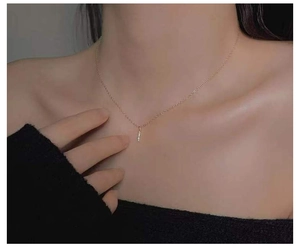 Close-up of elegant 14k gold plated bar necklace with shimmering diamonds on a model