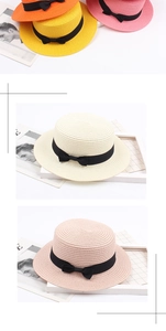 Détail de chapeaux de paille tressés avec nœuds en ruban noir en plusieurs couleurs vives