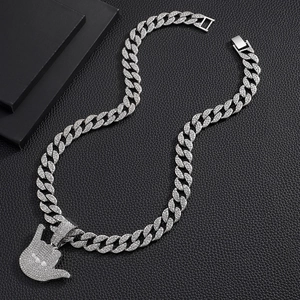 Detail of hip hop Cuban link chain with iced out hand gesture pendant on black leather