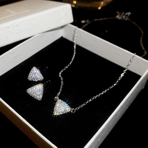 Vue détaillée de l'ensemble collier et boucles d'oreilles triangle argenté avec zircon