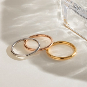 Detailed view of minimalist stacking rings in gold, silver, and rose gold finishes