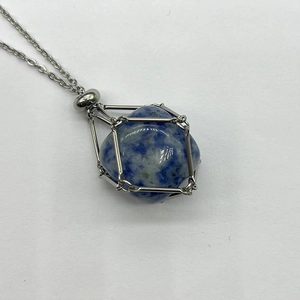 Detailed macro of a blue and white crystal stone wrapped in a silver wire cage pendant