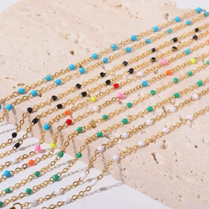 Detail of bohemian gold stainless steel chains with colorful enamel beads on stone