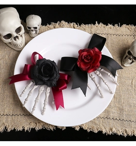 Detail of Halloween hair clips with skeleton hands, roses and ribbon bows on a plate