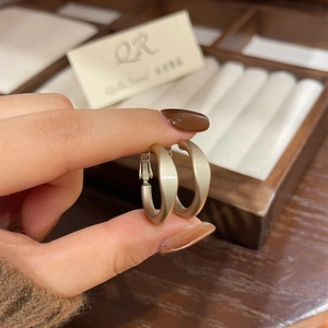 Matte champagne gold hoop earrings in a wide C-shape design for a minimalist modern look