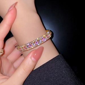 Detailansicht des vergoldeten Armbands mit pinkfarbenen und lila Kristallen