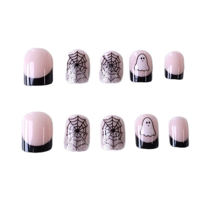 Faux ongles d'Halloween avec toiles d'araignées noires et fantômes sur fond rose