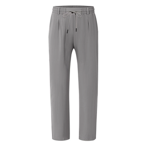 Detail of grey linen pants featuring an elastic drawstring waistband and textured fabric