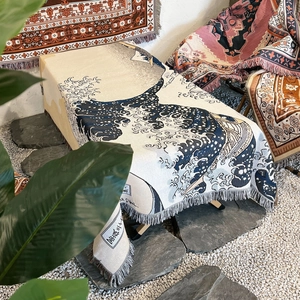 Detail of woven jacquard blanket with The Great Wave pattern and navy fringed edges