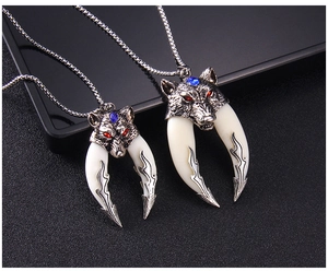 Detailed view of tribal wolf head pendant with faux tusk and blue gemstone on black background