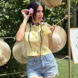 Women's summer casual set featuring yellow sleeveless button vest and ripped denim shorts