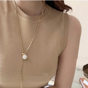 Minimalist long adjustable gold chain necklace with a large white round pearl pendant