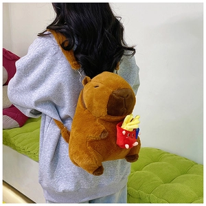 Capybara plush backpack with a red french fries keychain shown on a model's back