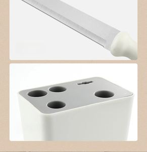Detail of sharp stainless steel blades and white integrated kitchen tool storage block