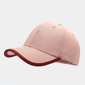Dettaglio del cappellino rosa con bordo bordeaux a contrasto e trama in tessuto twill