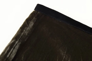 Dettaglio della gonna in velluto verde oliva scuro con elastico nero in vita