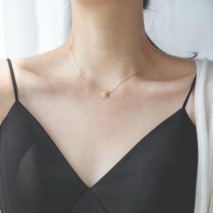 Elegant gold daisy pendant necklace for women worn as a minimalist choker style jewelry
