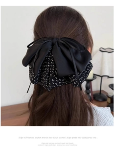 Detail view of a layered French leopard print and black silk bow hair claw clip