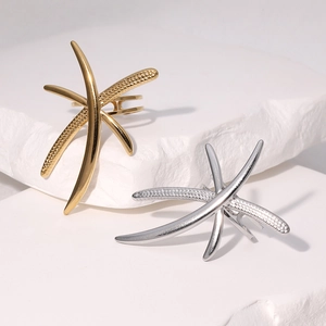 Artistic dragonfly stainless steel rings in gold and silver set on white stone pedestals