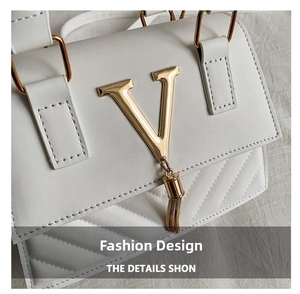 Detail of white PU leather bag featuring gold V-shaped hardware and quilted stitching