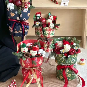 Christmas bouquet with red roses pine cones and snowman doll in festive packaging