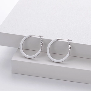 Detailed close-up of white oval hoop earrings with 925 silver clasp on a white platform
