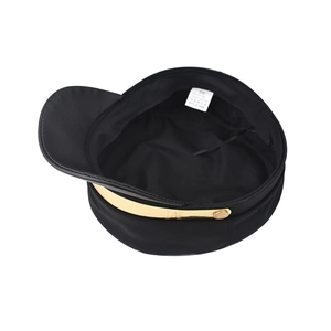 Detail view showing interior label and golden metal M logo band of black octagonal hat