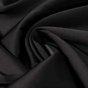 Gros plan sur le tissu en satin de soie noir montrant une texture lisse et brillante
