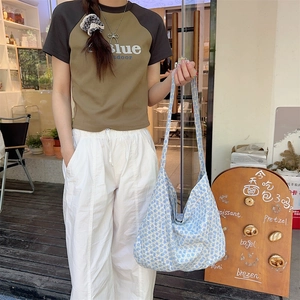 Detailed texture of floral canvas tote bag with shoulder strap in a cafe setting
