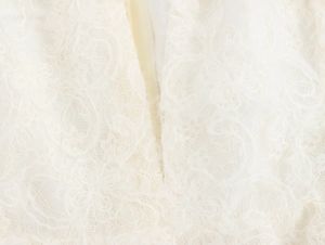Close-up of ivory lace texture and invisible zipper detail on French v-neck dress