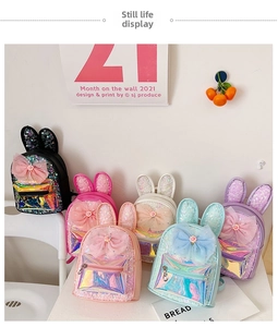 Close-up of colorful sequin mini backpacks for kids with bunny ears and large mesh bows