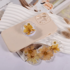 Details der transparenten Handy-Sockel mit echten Pressblumen auf beiger Silikonhülle