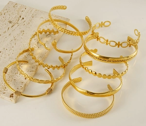 Close-up of assorted vintage gold stainless steel open bangles with diverse textures