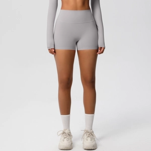 Detail of high waisted dark grey yoga shorts paired with sports socks and sneakers