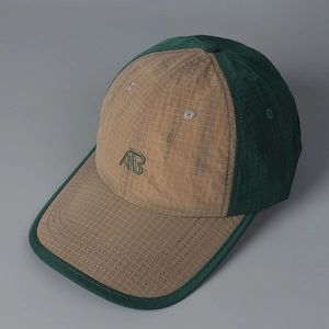 Macro detail of khaki and green ripstop nylon baseball cap with AB letter embroidery