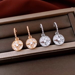 Detailed view of 18K gold plated and silver round starburst earrings with zircons