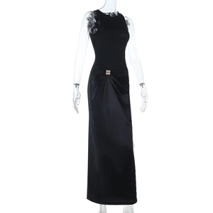 Détail de la taille de robe en satin noir avec boucle en métal et plis élégants